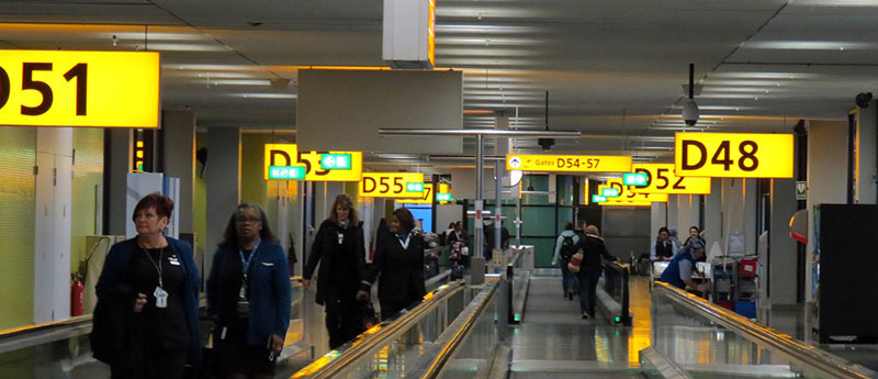 Photo of a generic airport terminal with boarding gate numbers in yellow.